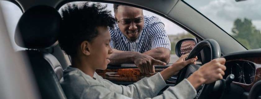 A father teaching his son how to drive a car