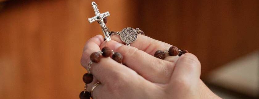 praying hands with rosary and does god work
