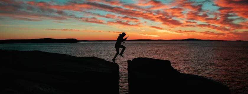 man jumping on rock and trusting god in all circumstances