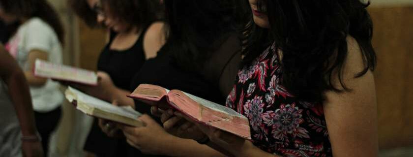 women standing and reading bible and apply the word of god