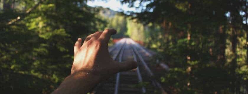 hand reaching out train tracks and waiting on god