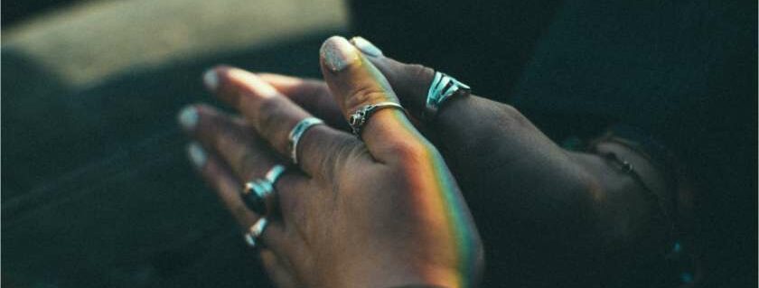 hands in prayer with rainbow lights