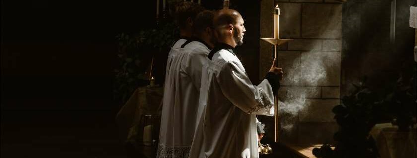 priests kneeling while holding candles