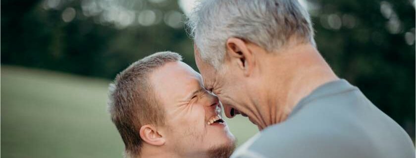 father and son laughing with foreheads close together