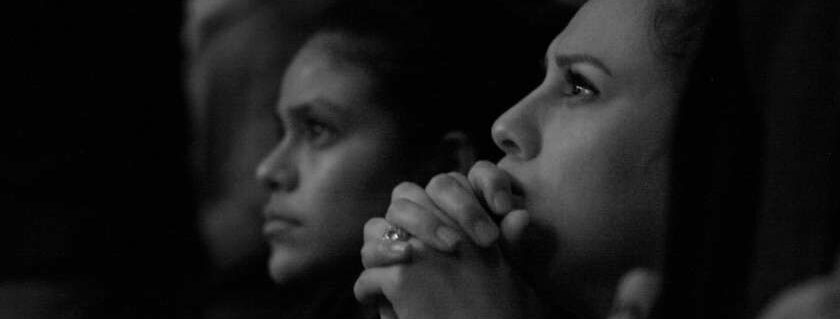 girls praying black and white