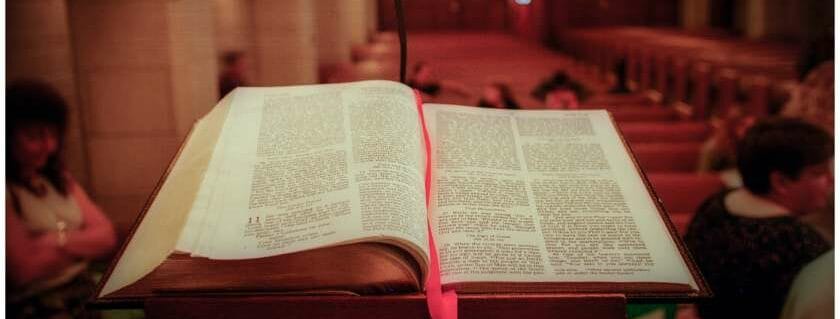 open bible being held up inside a church