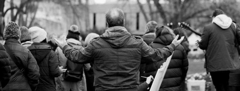 black and white photo of man at a rally with arms outstretched