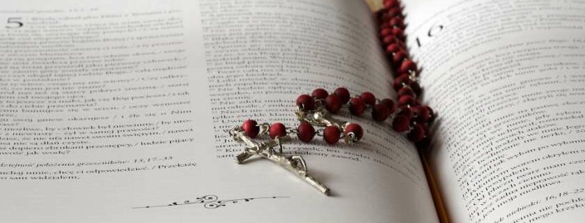 rosary on top of an opened bible book and jesus heals on the sabbath