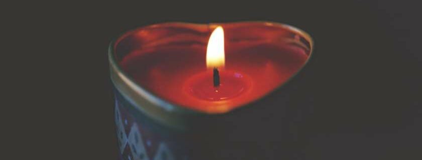 heart shaped lit candle against black background and search me o god and know my heart
