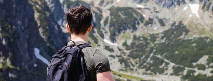 man carrying his backpack on top of mountains and how to overcome doubt in faith