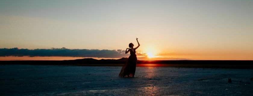 silhouette of a lady dancing by the seashore at sunset and psalms that praise god