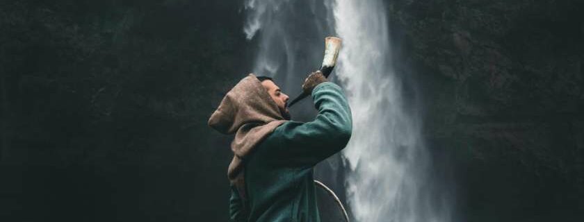 man blowing horn by waterfall and horn of salvation