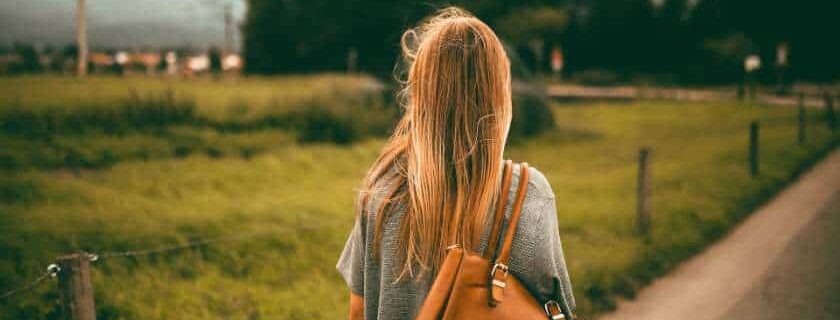 woman carrying brown leather bag and walk humbly with your god