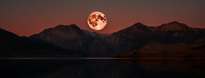 blood moon reflected on a tranquil lake and blood meaning in the bible